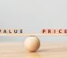 Wooden seesaw scale empty on wooden sphere on wood table with wording VALUE and PRICE balancing